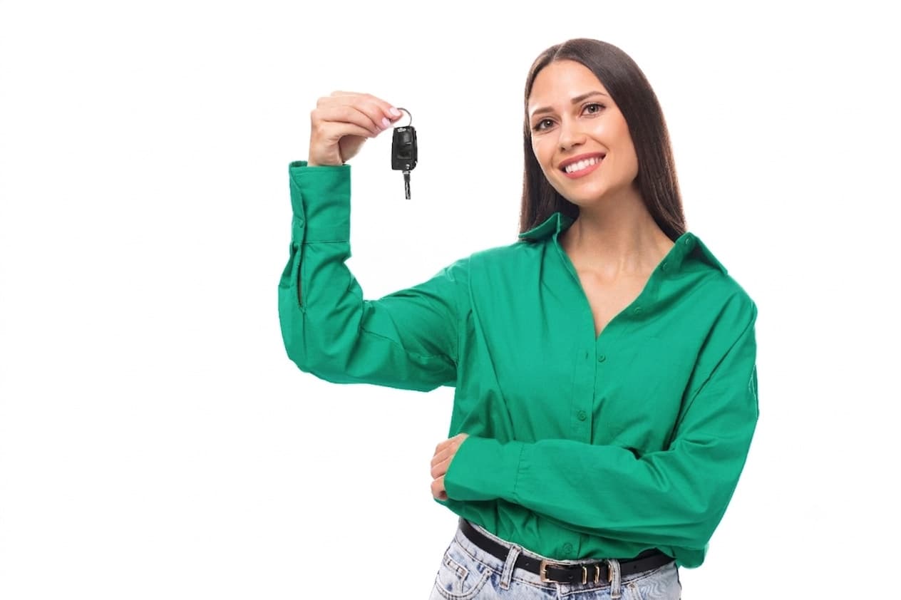 A smiling customer holding up the keys to her new vehicle